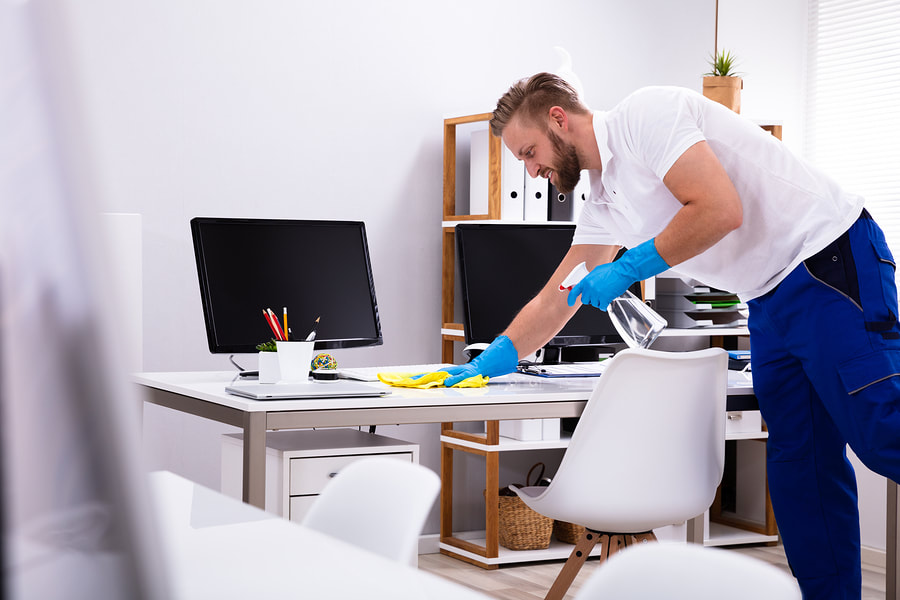 man cleaning the computer table